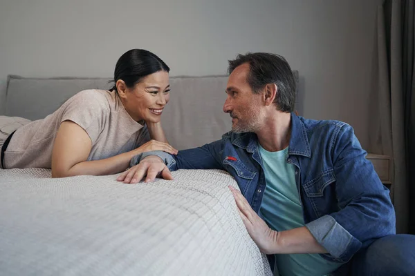 Alegre pareja madura casada comunicándose en el dormitorio — Foto de Stock