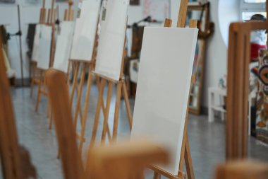 Sanat stüdyosunun ortasında duran ahşap şövaleler.