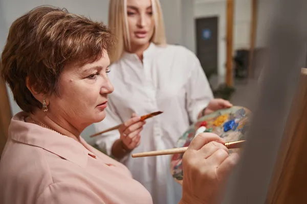 Portret poważnej samicy stojącej blisko sztalugi — Zdjęcie stockowe