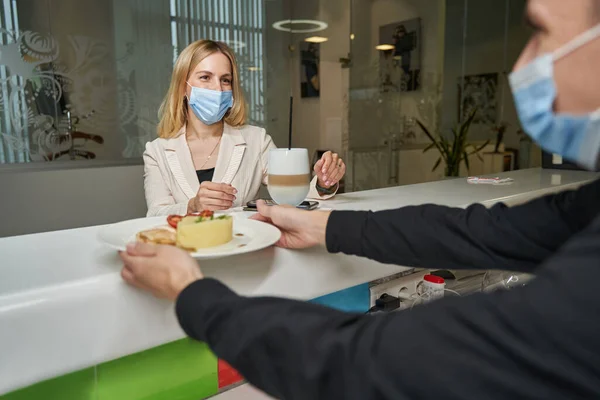 Verkoper geeft dessert aan vrouw in snackbar hotel — Stockfoto