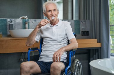 Mutlu adam sabah banyoda rutin işler yapıyor.