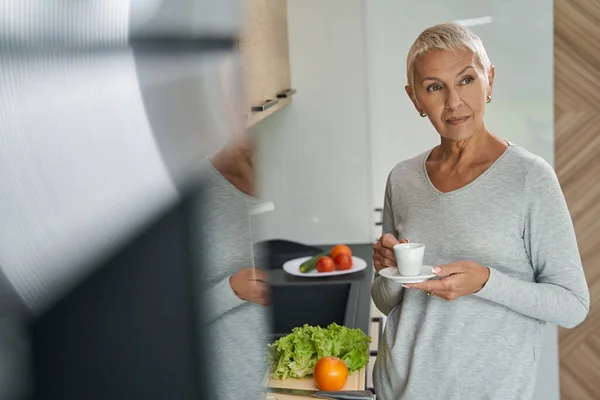 Pensativo mujer madura disfrutando de su café de la mañana — Foto de Stock