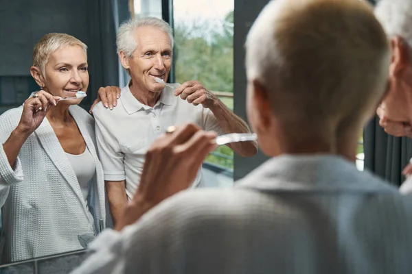 Positivo encantado pareja envejecida limpieza de sus dientes — Foto de Stock