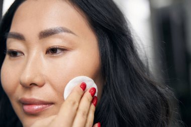 Süngerli zarif kadın kuaförde makyaj yapıyor.