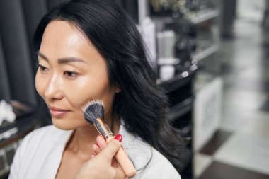 Odada makyaj yapan zarif bir bayan.