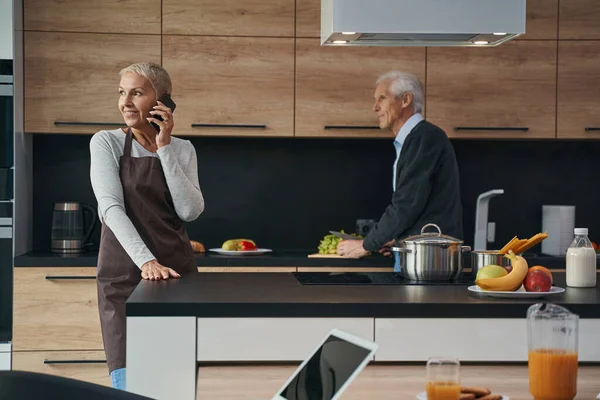 Düşünceli gri saçlı adam pencereye bakıyor.