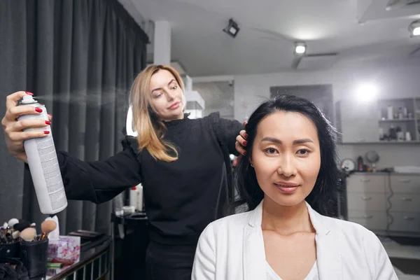 Азиатская женщина сидит в парикмахерской во время процесса красоты — стоковое фото