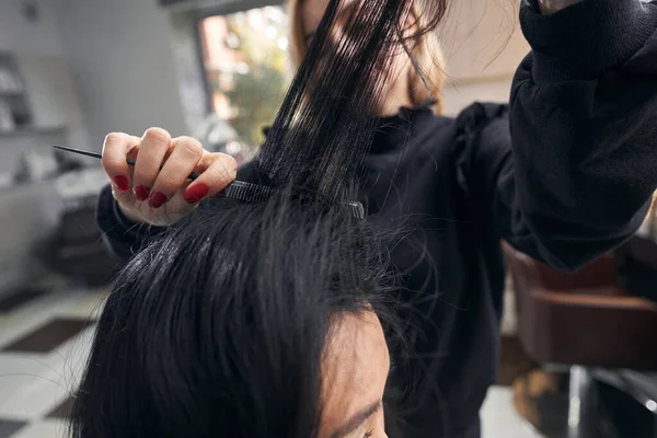 Картина перукаря, що розчісує волосся клієнтів в салоні краси — стокове фото