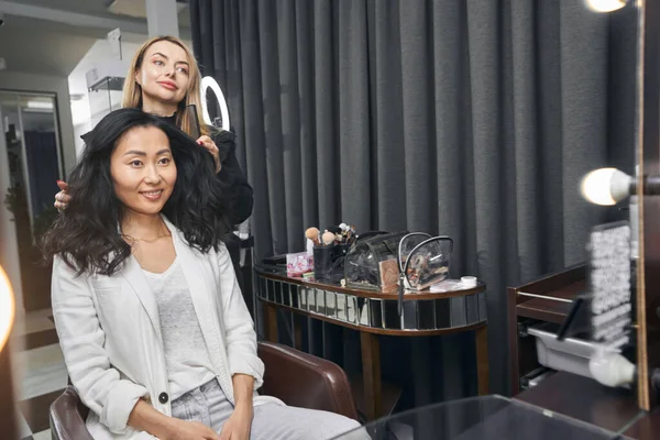 Блонда Кавказька перукарка, що показує результат процедури з догляду за волоссям в салоні. — стокове фото