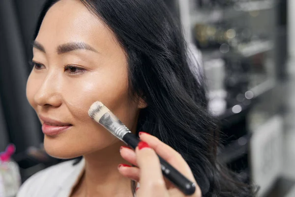 Mulher elegante bonita pintando cosméticos no salão de beleza — Fotografia de Stock