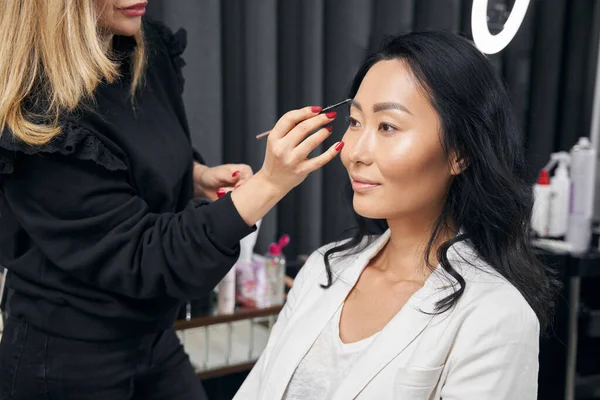 Beyaz elbiseli hoş, zarif bir kadın profesyonel bir görünüm kazanıyor.