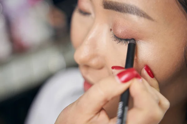 Charmante Frau erhält professionelles Make-up mit professioneller Kosmetik — Stockfoto