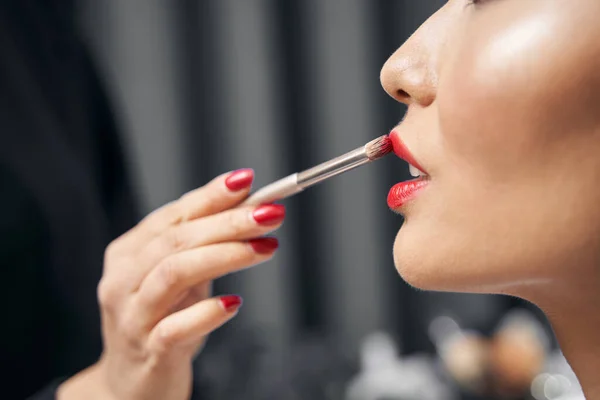 Artista de maquiagem feminina não reconhecida usando delineador labial no salão moderno — Fotografia de Stock