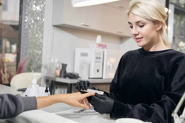 Manikürcüde çalışan mutlu çekici kadın üstat