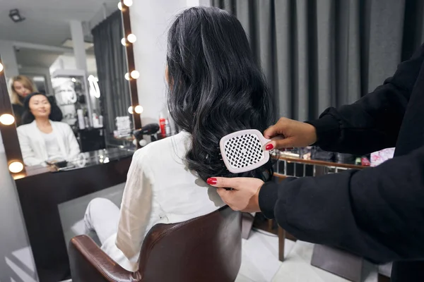 Beyaz elbiseli tanınmayan çekici kadın kuaförde kuaförlük yapıyor.