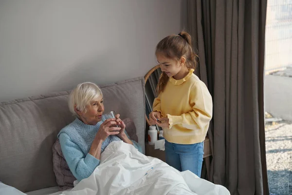 Nieta atenta ayudar a la abuela enfermera volver a la salud — Foto de Stock