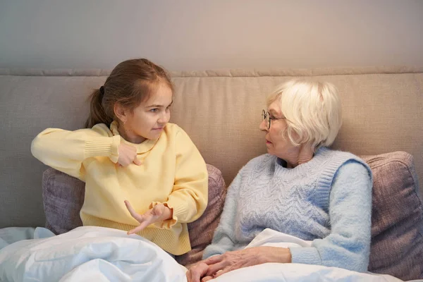 Kleindochter en oma communiceren met behulp van gebarentaal — Stockfoto