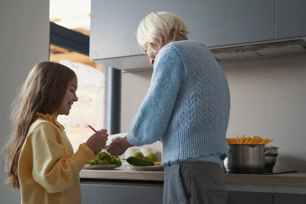 Gioioso bambino che cucina insieme a sua nonna in cucina — Foto Stock