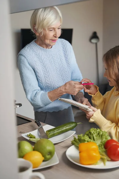 Amar a la abuela ayudando a un niño con la tarea —  Fotos de Stock