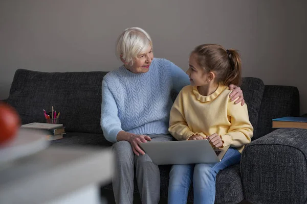 Adorable niña haciendo contacto visual con su encantadora abuela — Foto de Stock