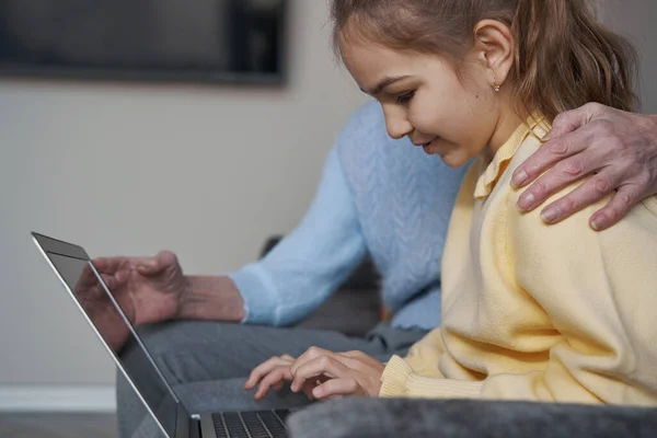 Концентрированный ребенок, использующий ноутбук для учебы из дома — стоковое фото