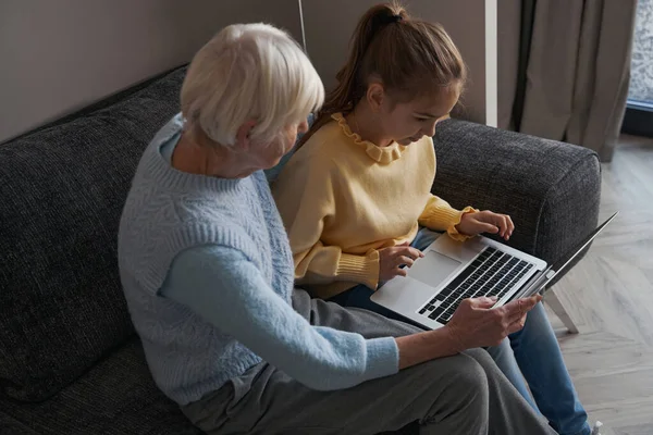 Окаменевший ребенок пользовался ноутбуком с бабушкой — стоковое фото