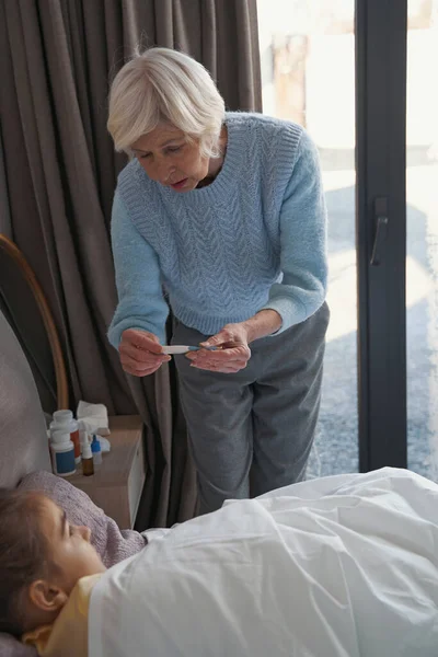 Mujer mayor amamantando niño enfermo de nuevo a la salud — Foto de Stock