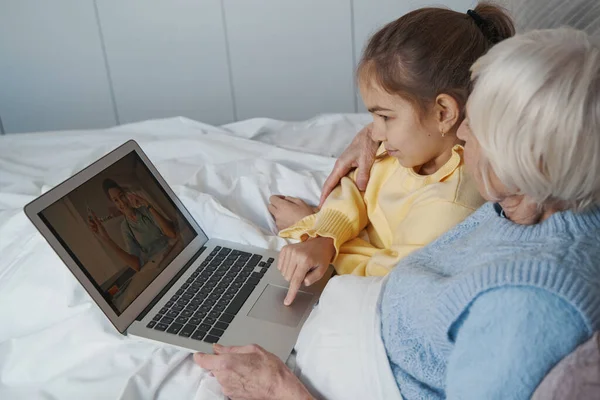 Умный ребенок изучает медицинские решения для своей бабушки онлайн — стоковое фото