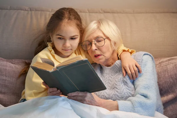 Linda niña y su abuela leyendo un poco antes de dormir — Foto de Stock