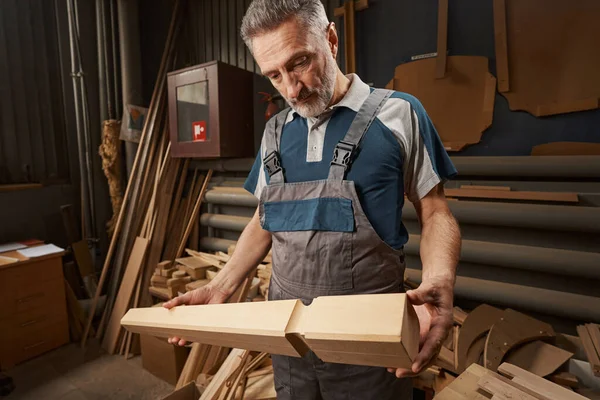 Serious bearded master looking at table leg — Foto Stock