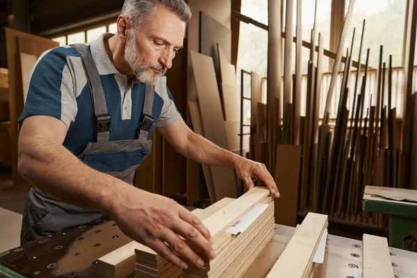 Συμπυκνωμένος γενειοφόρος άνδρας που λαμβάνει ξυλεία από ξύλο — Φωτογραφία Αρχείου
