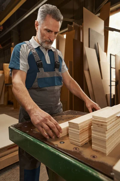 Portret starszego pracownika patrzącego na drewno — Zdjęcie stockowe