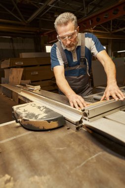 Koruyucu gözlük takan marangoza odaklanmış bir fotoğraf.