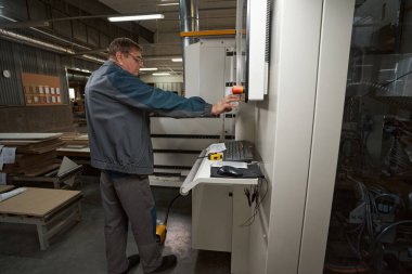 Modern makineye yakın duran profesyonel bir marangoz.