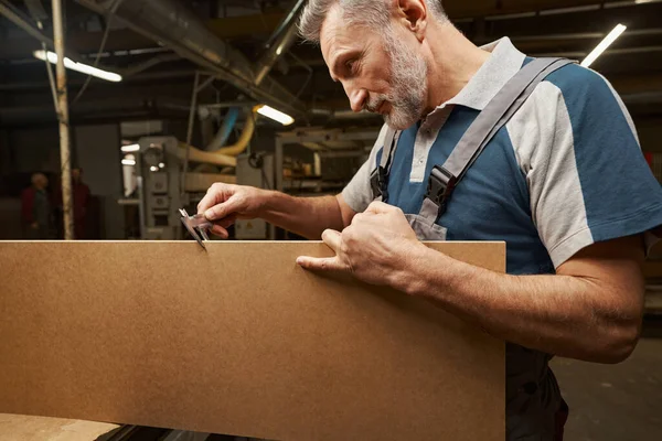 Cheerful male joiner working at manufacture of furniture — Foto Stock