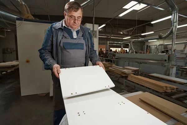 Serious male carpenter looking at wooden blanks — Foto Stock