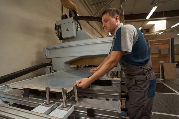 Handsome joiner putting veneer on the machine — Foto Stock