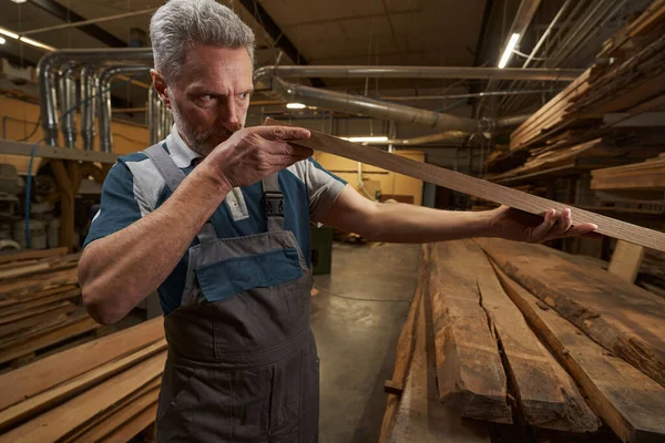 Professional male joiner checking quality of wood — Foto Stock