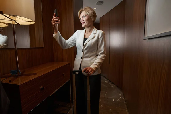 Business lady standing in hallway calling on phone — Stockfoto