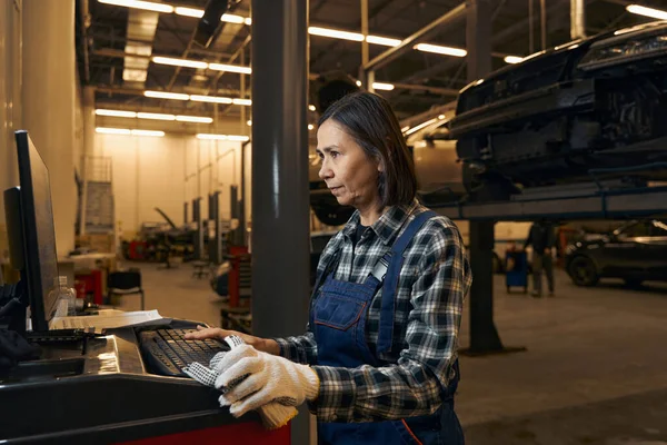 Successful brunette woman working as a mechanic on a factory — Stockfoto