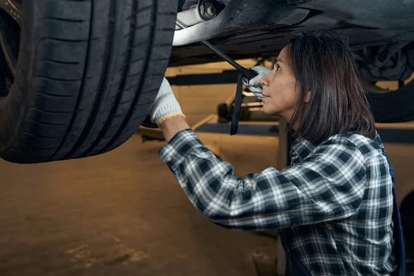 Focused woman doing her job at car repair shop — Zdjęcie stockowe