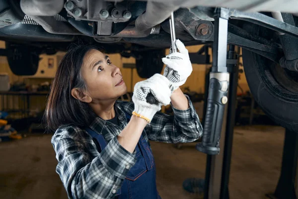 Professional female mechanic inspecting all parts of the car — Stockfoto