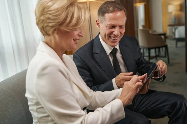 Business colleague reading information on phone during meeting in hotel room — ストック写真