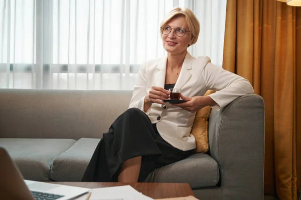 Happy businesswoman sitting in hotel room waiting for someone — Fotografia de Stock