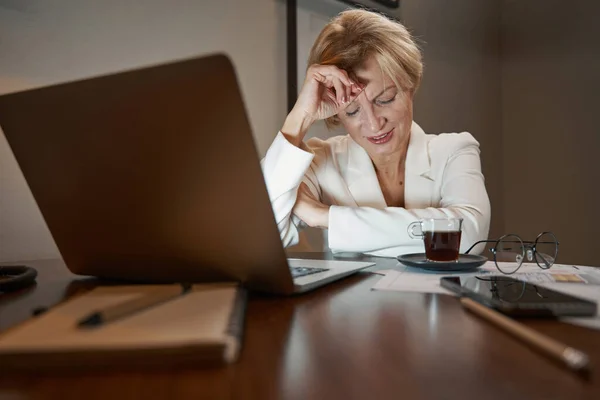 Tired businesswoman overworking in hotel room at night — Stockfoto