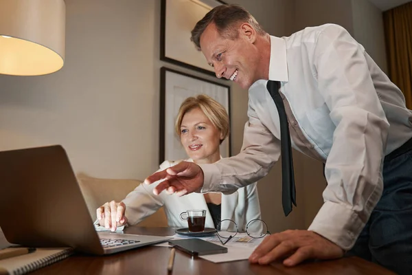 Επιχειρηματικοί συνεργάτες συζητούν κάτι στο δωμάτιο του ξενοδοχείου, εργάζονται με laptop — Φωτογραφία Αρχείου
