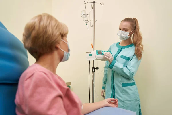 Trabajadora médica complacida comunicándose con su paciente — Foto de Stock
