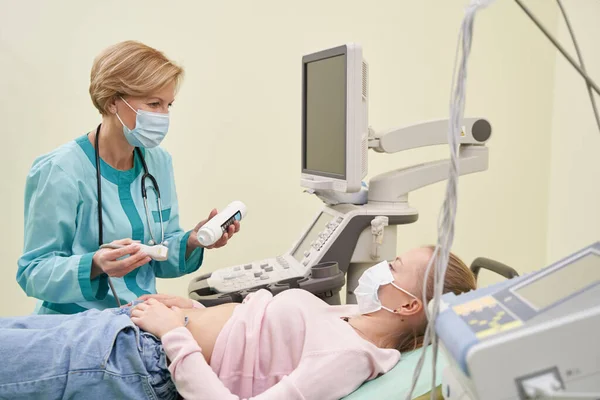 Piacevole medico che mette gel sullo stomaco — Foto Stock