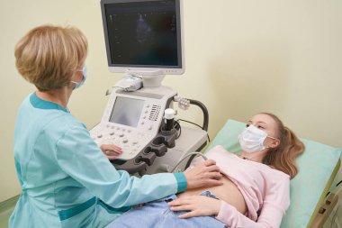 Tıbbi ekipman ekranına bakan uzman pratisyen.