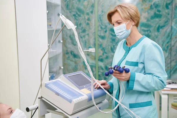 Assistente médico atento verificando o pulso do paciente — Fotografia de Stock